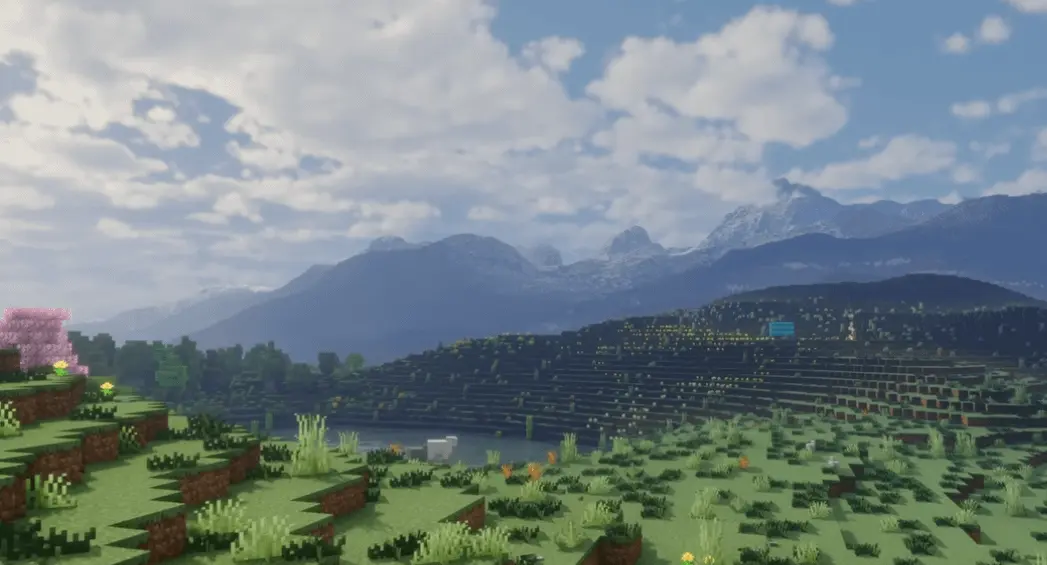 A scenic Minecraft landscape featuring mountains, a lake, and flowering trees.