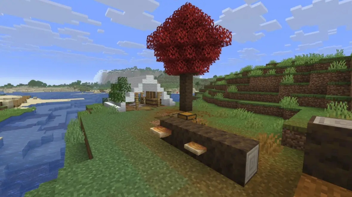 A scenic view of a Minecraft forest biome with a red tree and river.