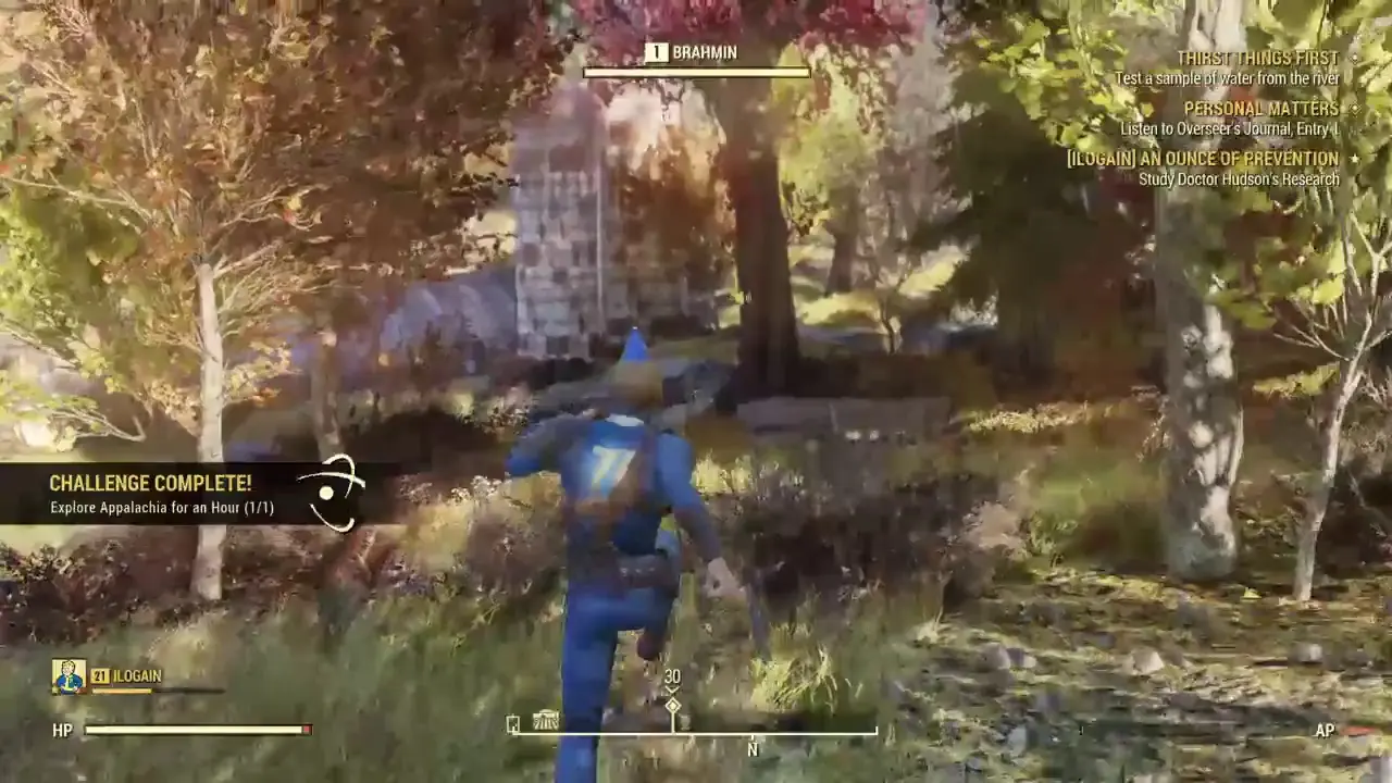 Third-person gameplay view of a character in a blue vault suit walking through a forest in Fallout 76
